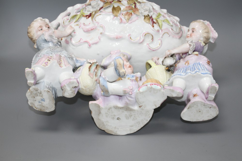 An early 20th century German porcelain centrepiece, with floral encrusted bowl supported by three children, height 28.5cm, width 44cm